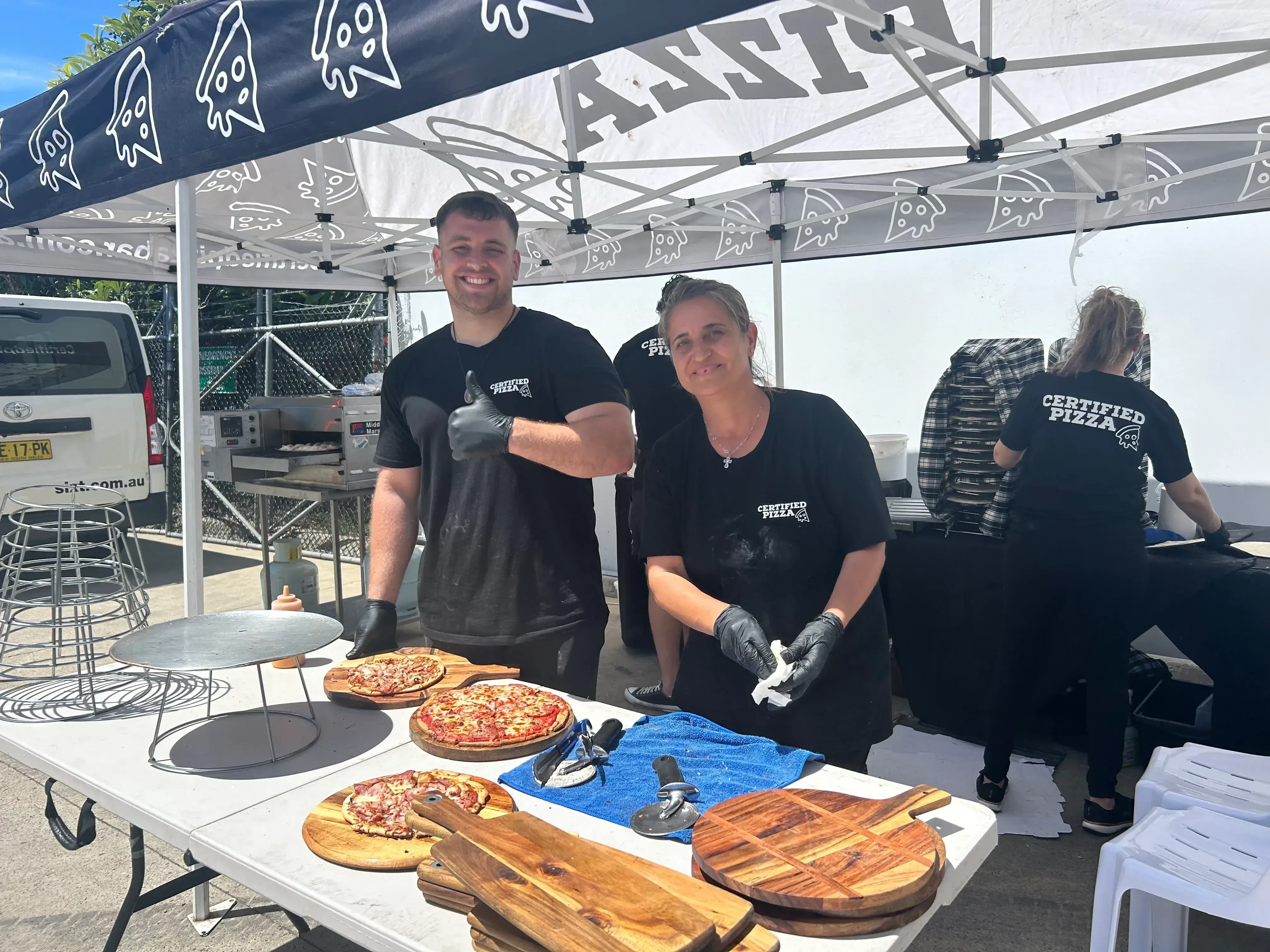 Certified Pizza Catering team serving fresh pizzas at the Bravofoods factory opening in Prestons NSW