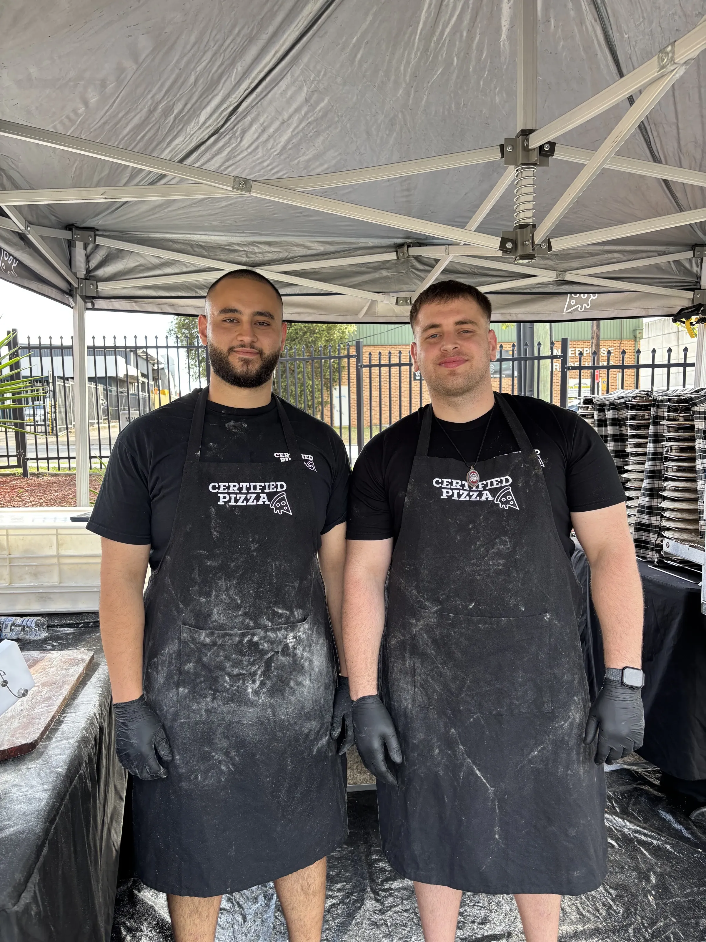 Certified Pizza Catering team in flour-dusted aprons at a mobile pizza event in Narellan NSW