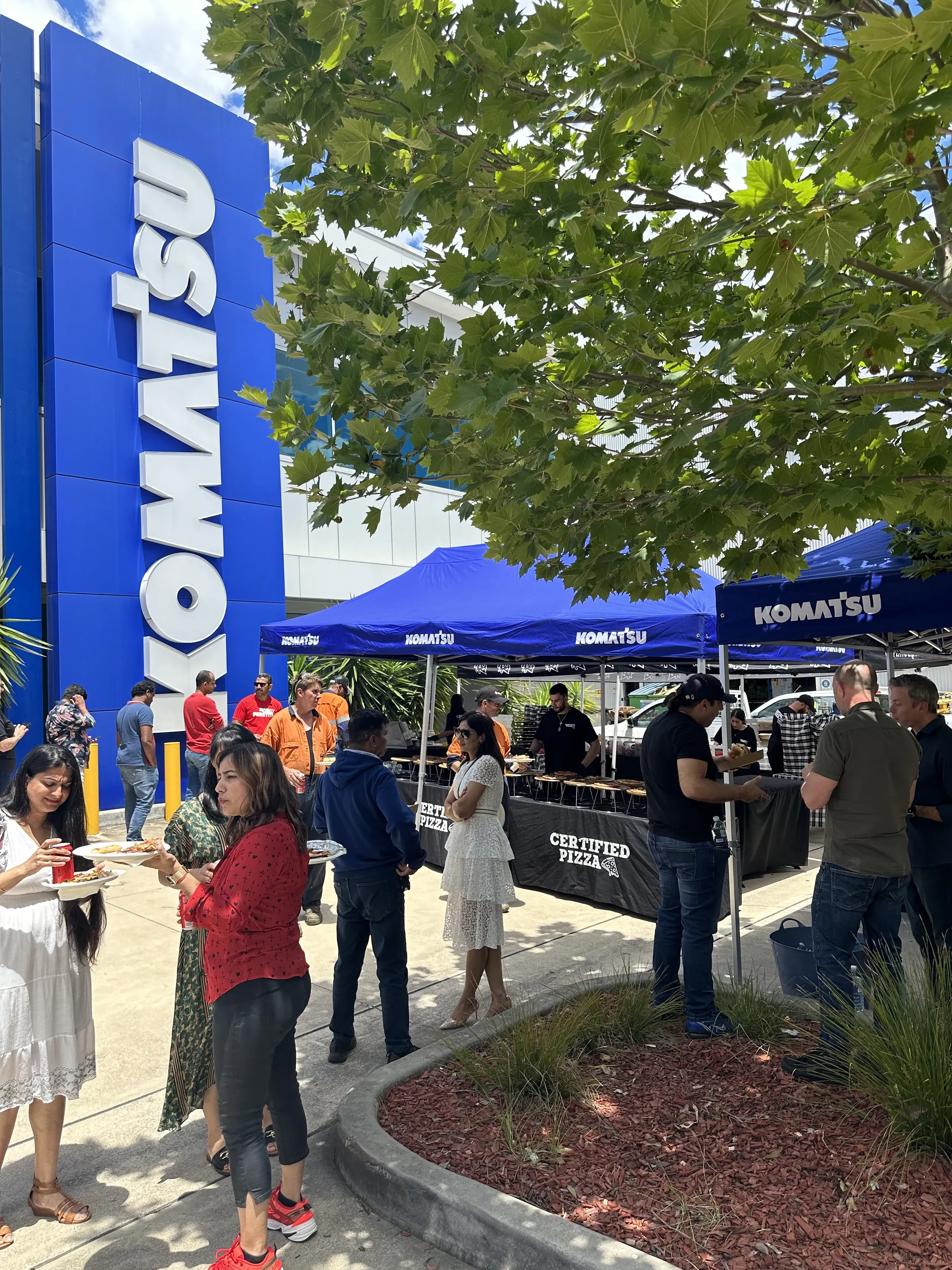 Komatsu staff enjoying pizza catering outside the Fairfield site