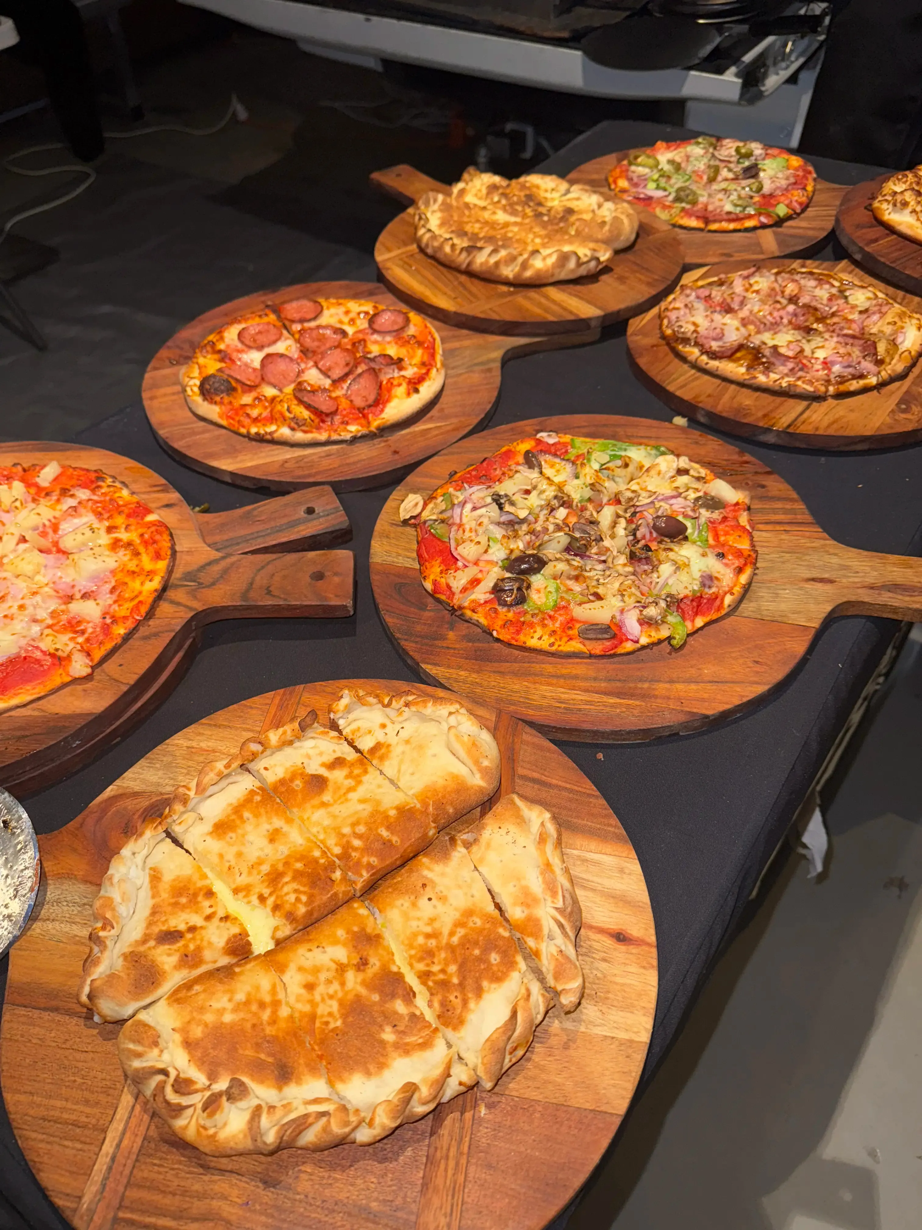 Unlimited pizza spread on wooden boards at a Sydney catering event